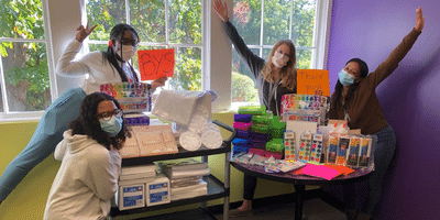 Nonprofit leaders at a local youth focused program posing with art therapy kits.