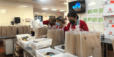 Volunteers package meals a local food pantry to help support community members with critical and chronic illnesses.
