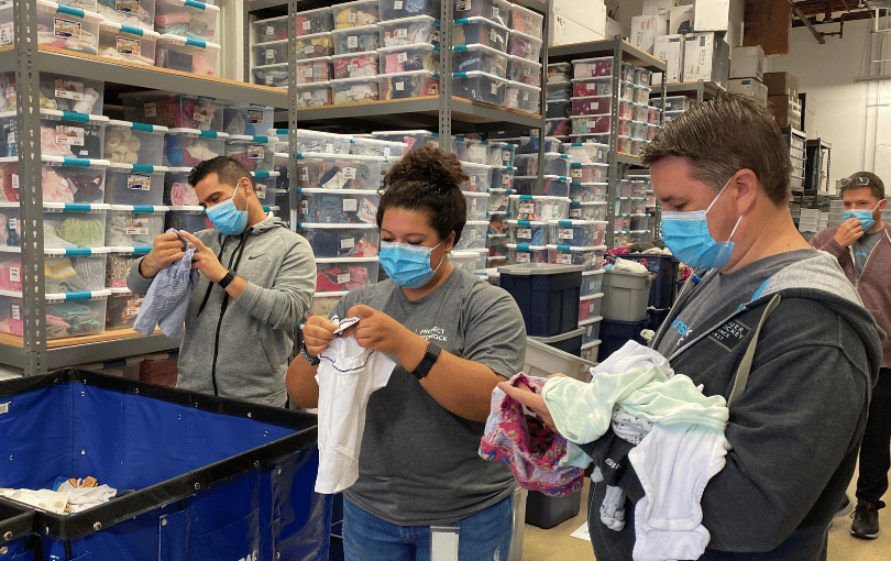 Volunteers sorting donations of baby clothes and toys at a local nonprofit.