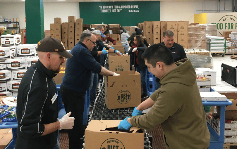 Volunteers packing meal boxes for community members at a nonprofit. 