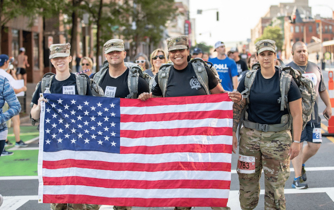Group of military members holding up an American flag.